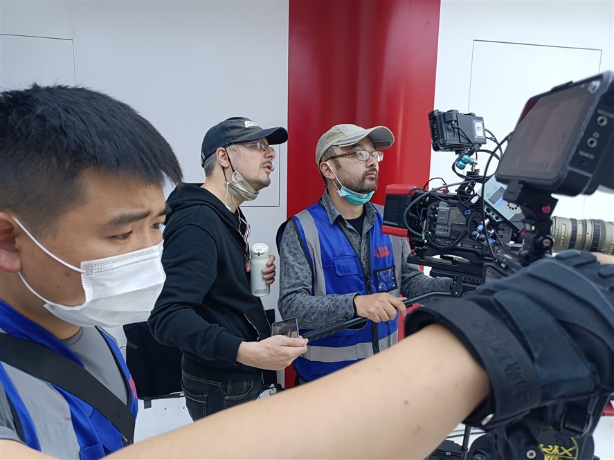 Camera crew reviewing a production setup inside a Shenzhen industrial site