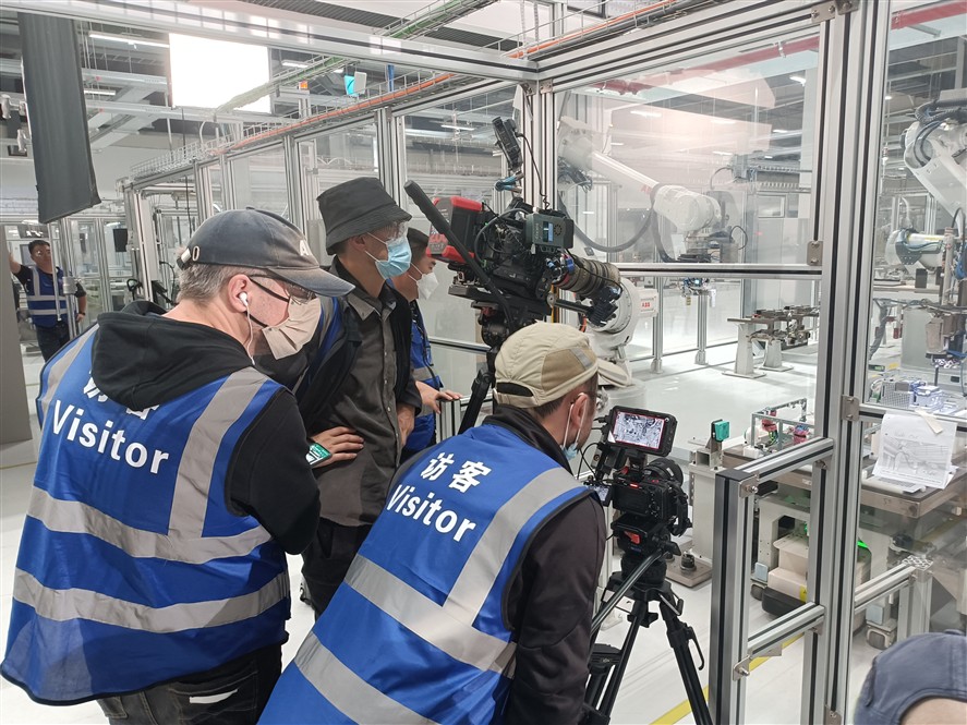 Industrial filming setup with camera crew inside a robotics facility in Shenzhen